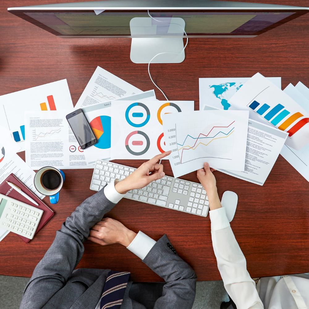 Stacks of financial reports and audit sheets laid out for review,symbolizing Finpage's Business Correspondence module used for partner performance monitoring, compliance tracking, and data-driven decision-making.