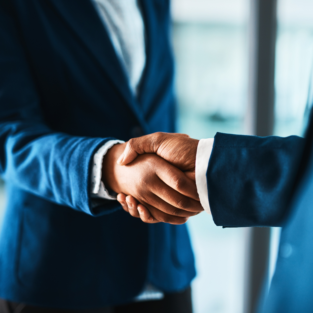 Two individuals shaking hands, representing Finpage's co-lending module for collaborative lending between financial institutions