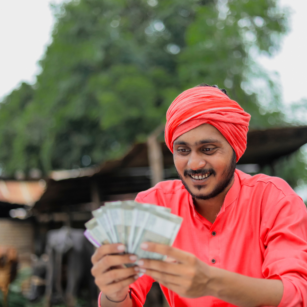 A rural milkman, counting cash received from an individual loan disbursed by an NBFC using Finpage's lending software.