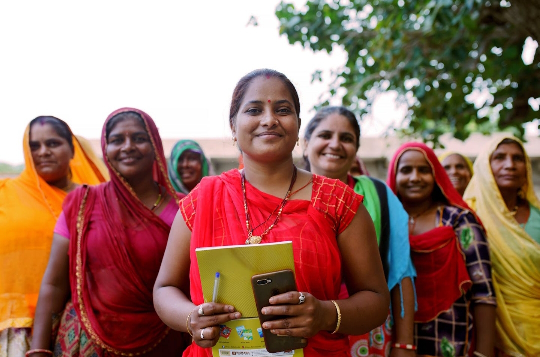 A group of cheerful rural women walking together after completing a GRT / CGT meeting, empowered and excited to begin their journey with Joint Group Lending facilitated by NBFCs and MFIs using Finpage's digital platform.